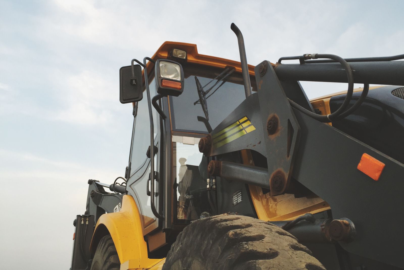 A yellow and black wheel loader against a clear sky